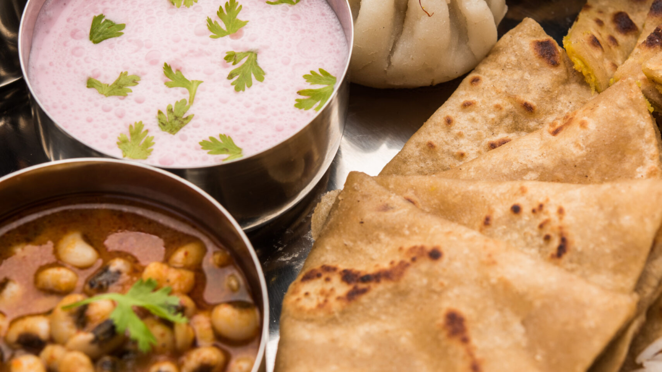 Maharashtrian food Thali or platter - Mumbai style Meal from Indian State Maharashtra includes, roti, rice, dal, sabji, sweet roti and rice, kadhi, Modak, papad etc